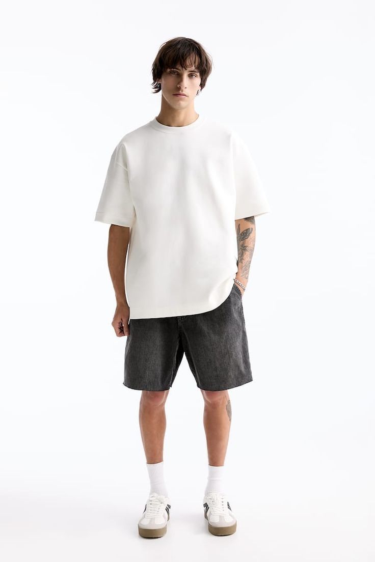 Male model in a white T-shirt and dark shorts